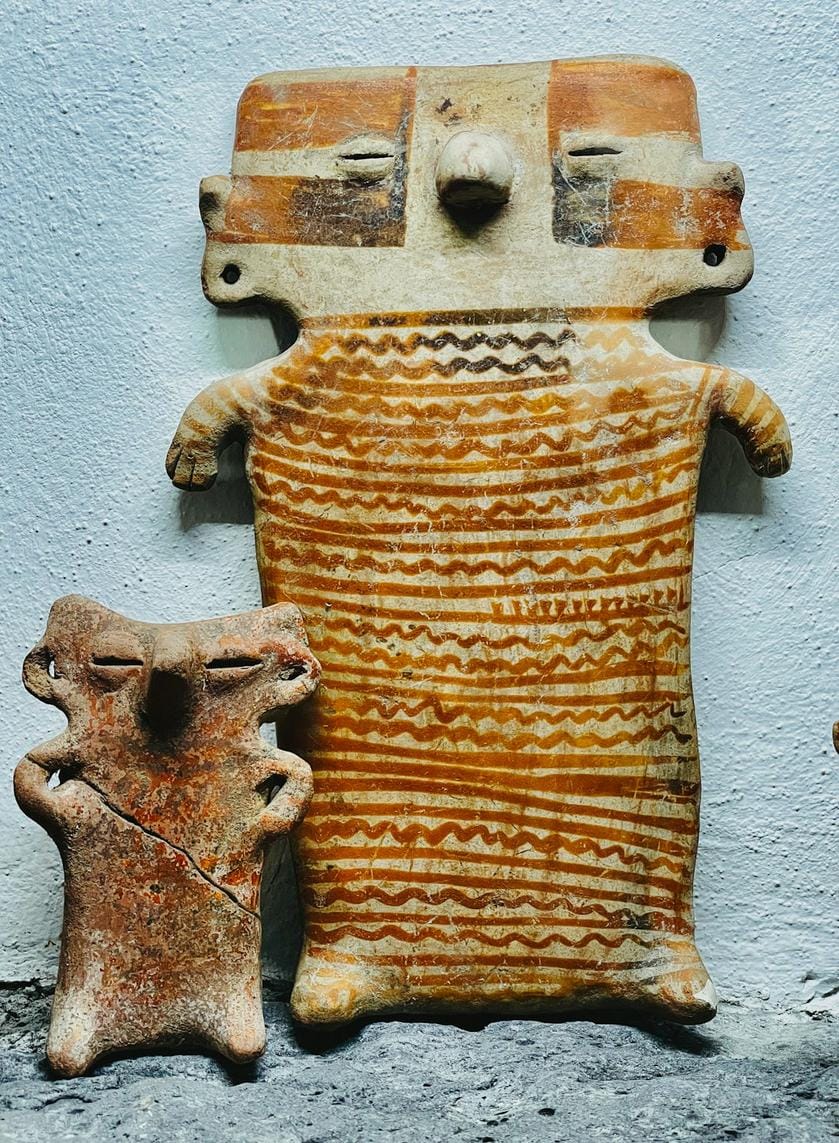 Photographs of Neolithic tools and artifacts discovered at the Taş Tepeler site, displayed in a modern museum setting.